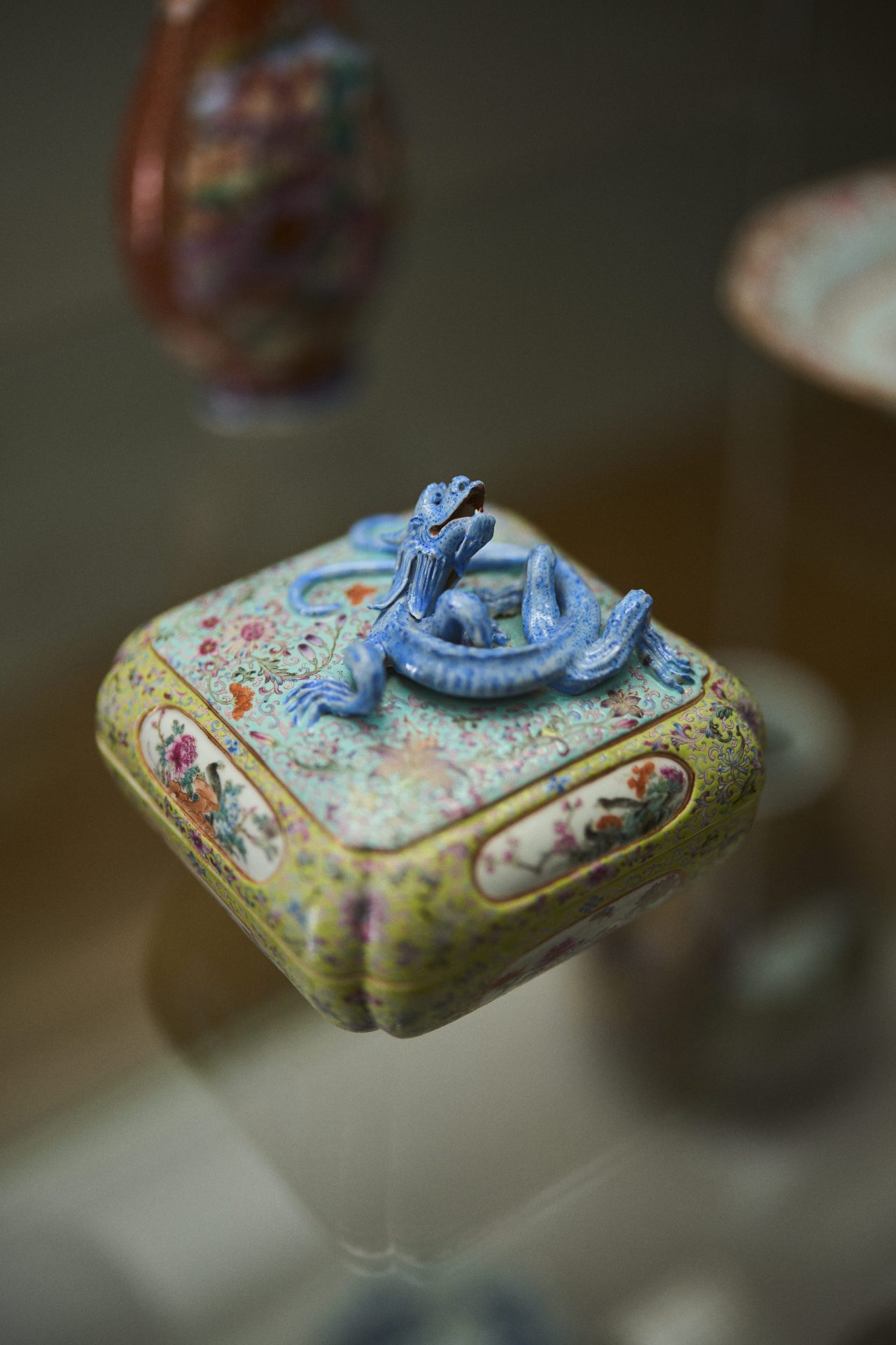 Bunte Box mit blauem Drachen auf der Oberseite, filigranen Details und floralen Mustern.