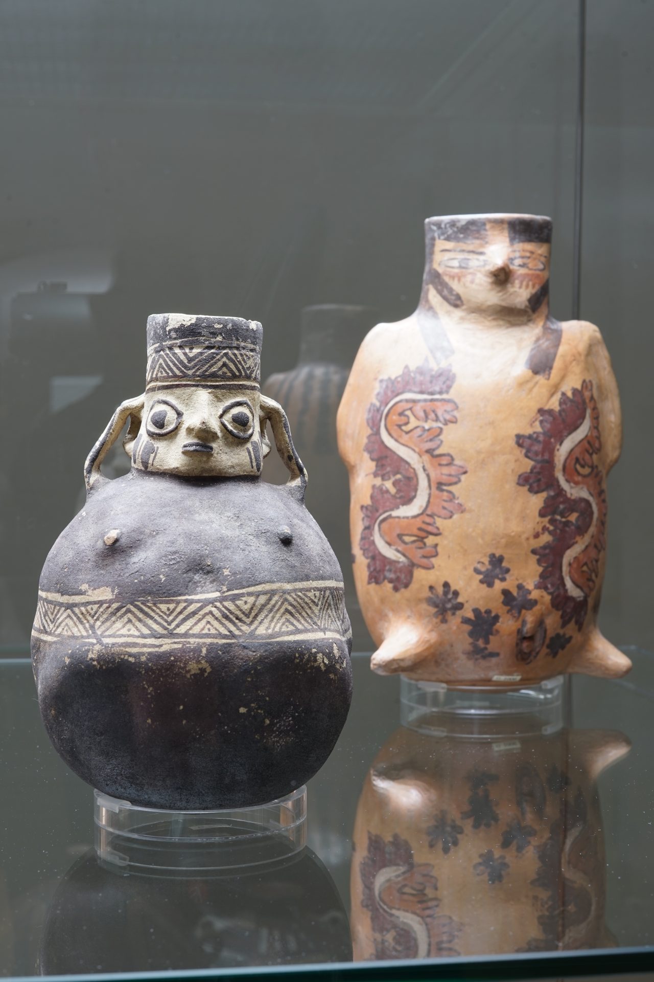 Zwei kunstvoll verzierte keramische Tonkrüge: einer mit Gesicht, der andere mit bunten Mustern, Peru