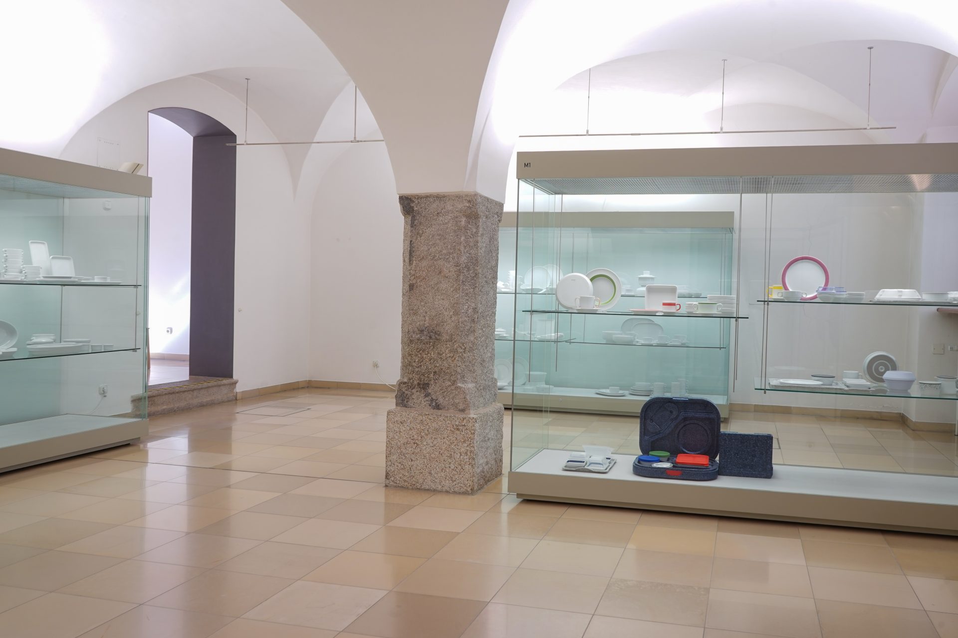 Ausstellungshalle mit Vitrinen für Geschirr und Keramiken in einem hellen, modernen Raum.